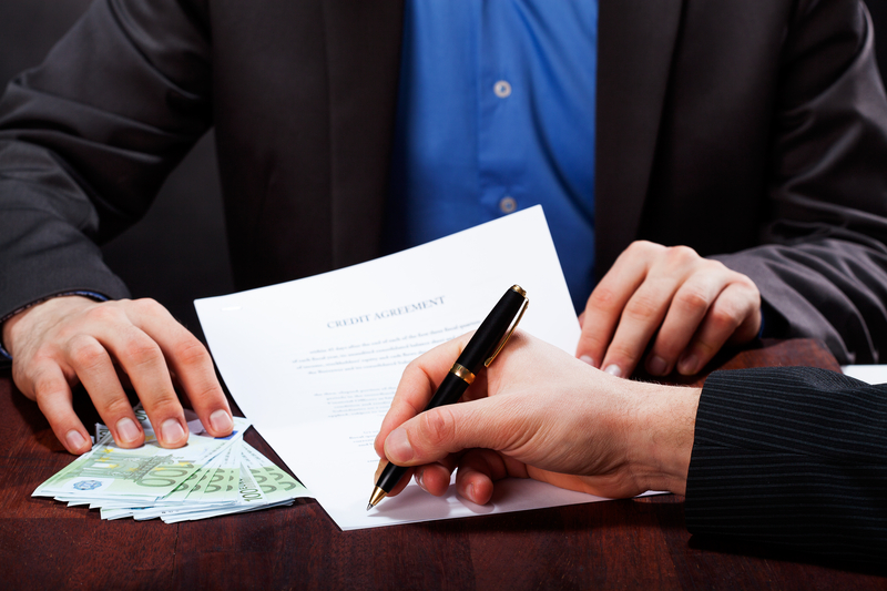 man signing an express cash loan agreement